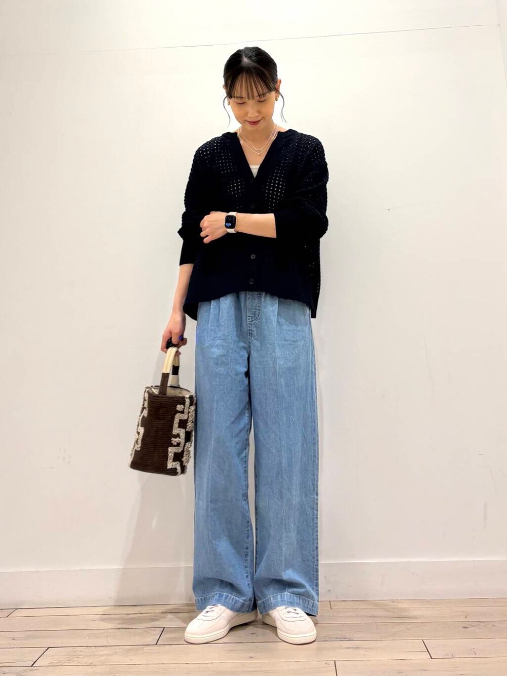 グリーン系のミリタリージャケット、ブルー系のデニムパンツ、ブルー系のカーディガン/ボレロを着用したレディースの春コーディネートの2枚目の写真