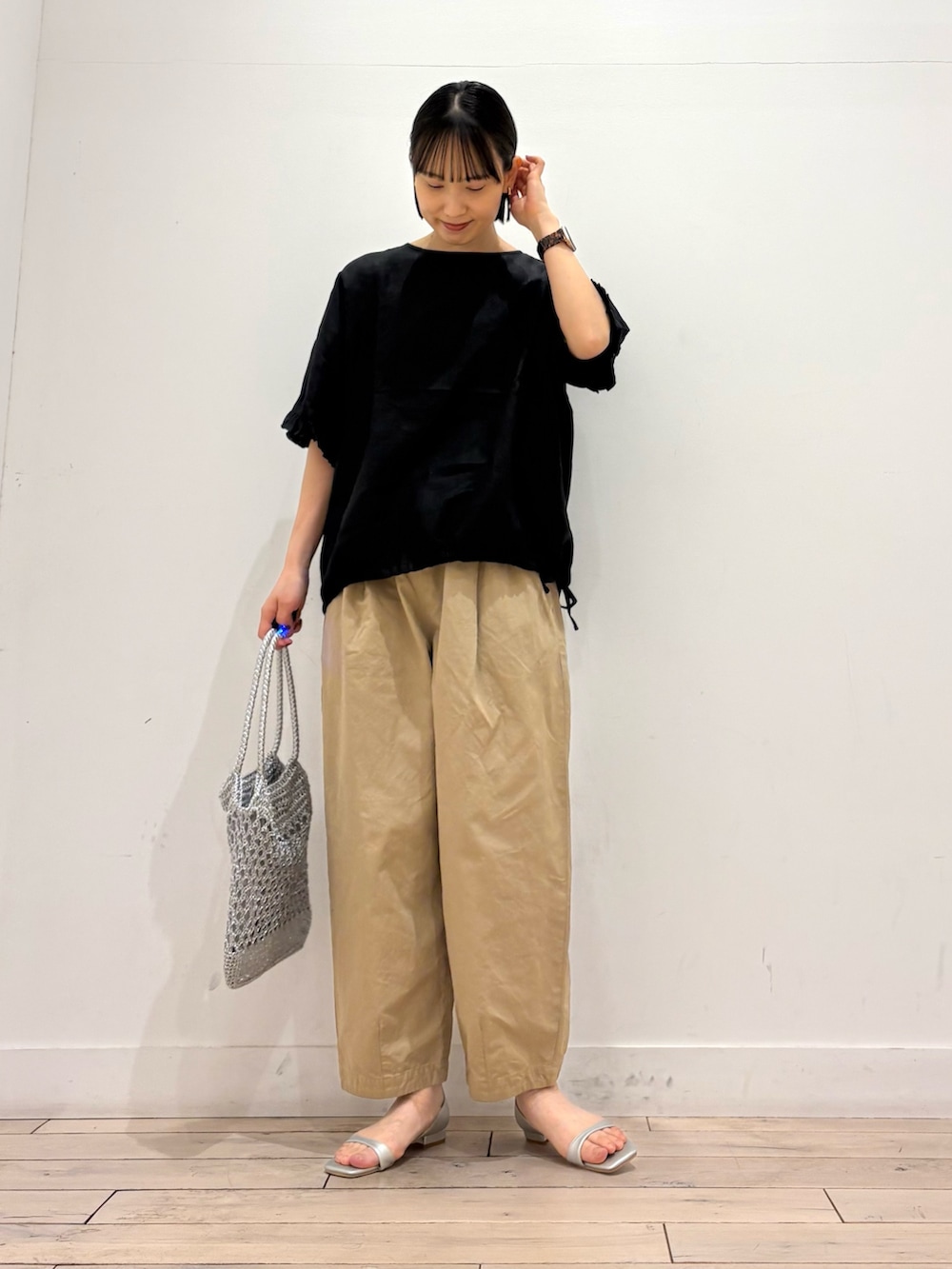 シルバー系のトートバッグ、シルバー系のサンダル、ベージュ系のその他パンツを着用したレディースの春コーディネートの2枚目の写真