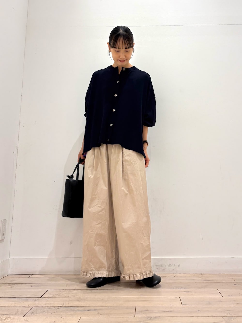 ブルー系のカーディガン/ボレロ、ベージュ系のその他パンツ、ブラック系のトートバッグを着用したレディースの秋コーディネートの2枚目の写真
