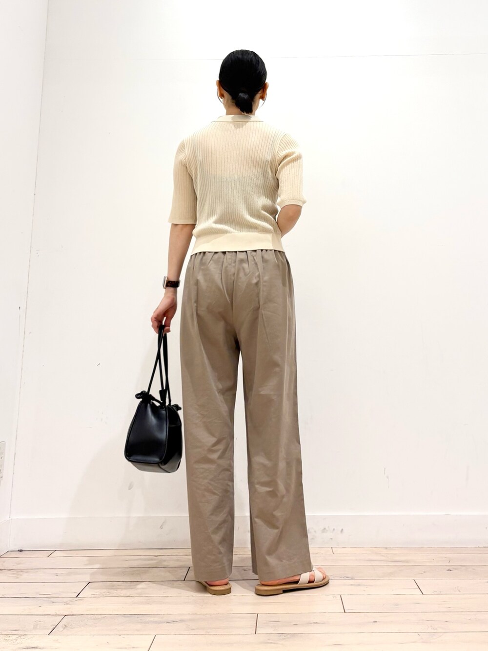 ホワイト系のニット/セーター、ベージュ系のその他パンツ、ブラック系のトートバッグを着用したレディースの夏コーディネートの5枚目の写真