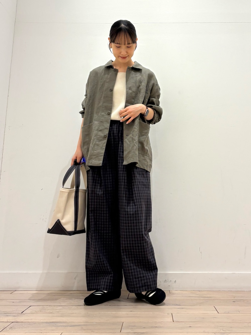 ホワイト系のタンクトップ、グレー系のカバーオール、グレー系のトートバッグを着用したレディースの春コーディネートの2枚目の写真