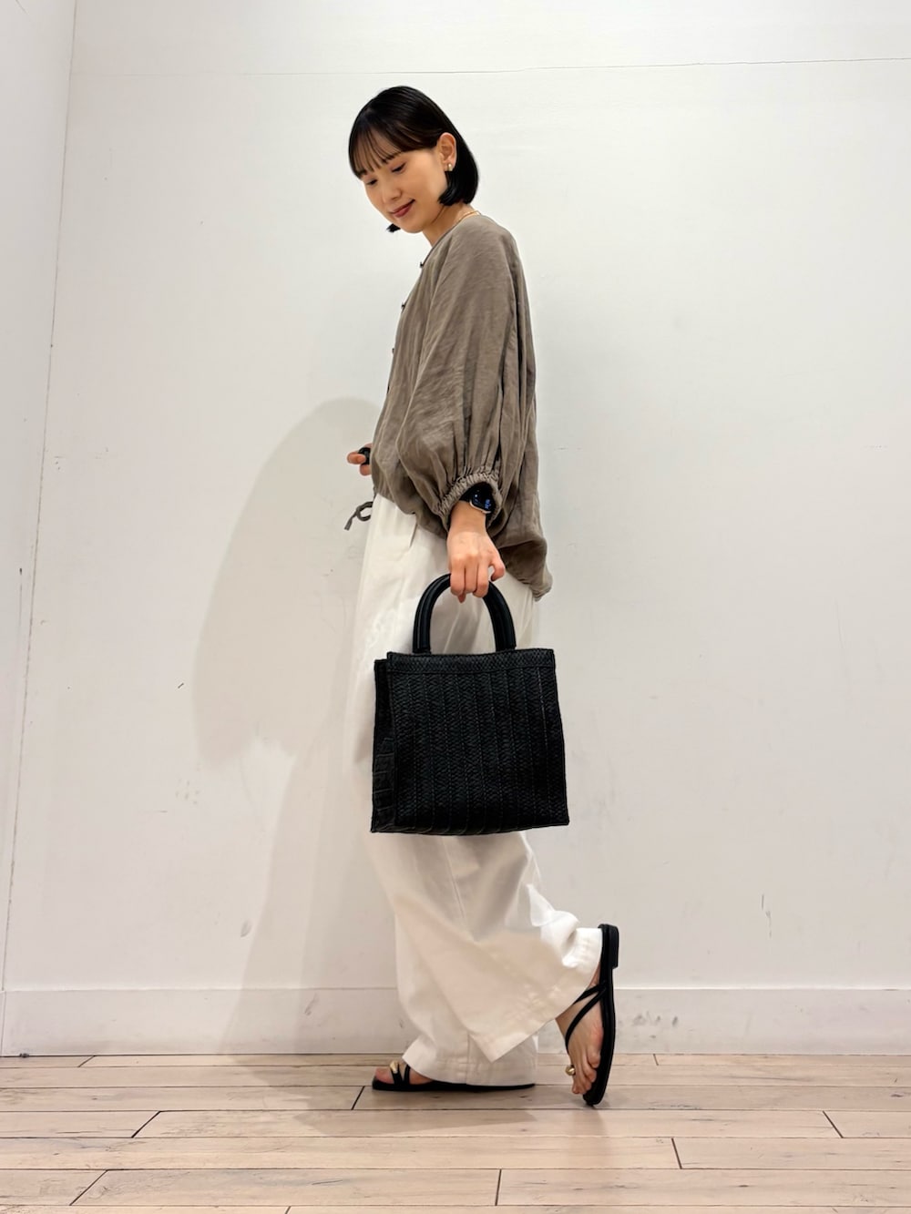 ホワイト系のその他パンツ、ブラック系のハンドバッグ、ブラック系のサンダルを着用したレディースの夏コーディネートの3枚目の写真