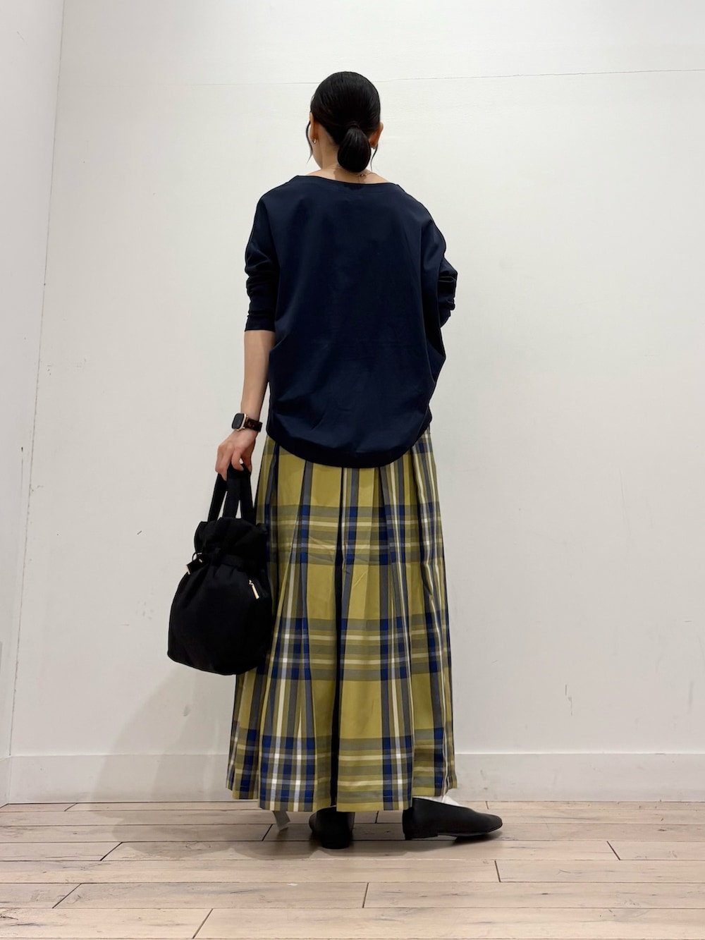 ブルー系のTシャツ/カットソー、イエロー系のスカート、ブラック系のトートバッグを着用したレディースの秋コーディネートの4枚目の写真
