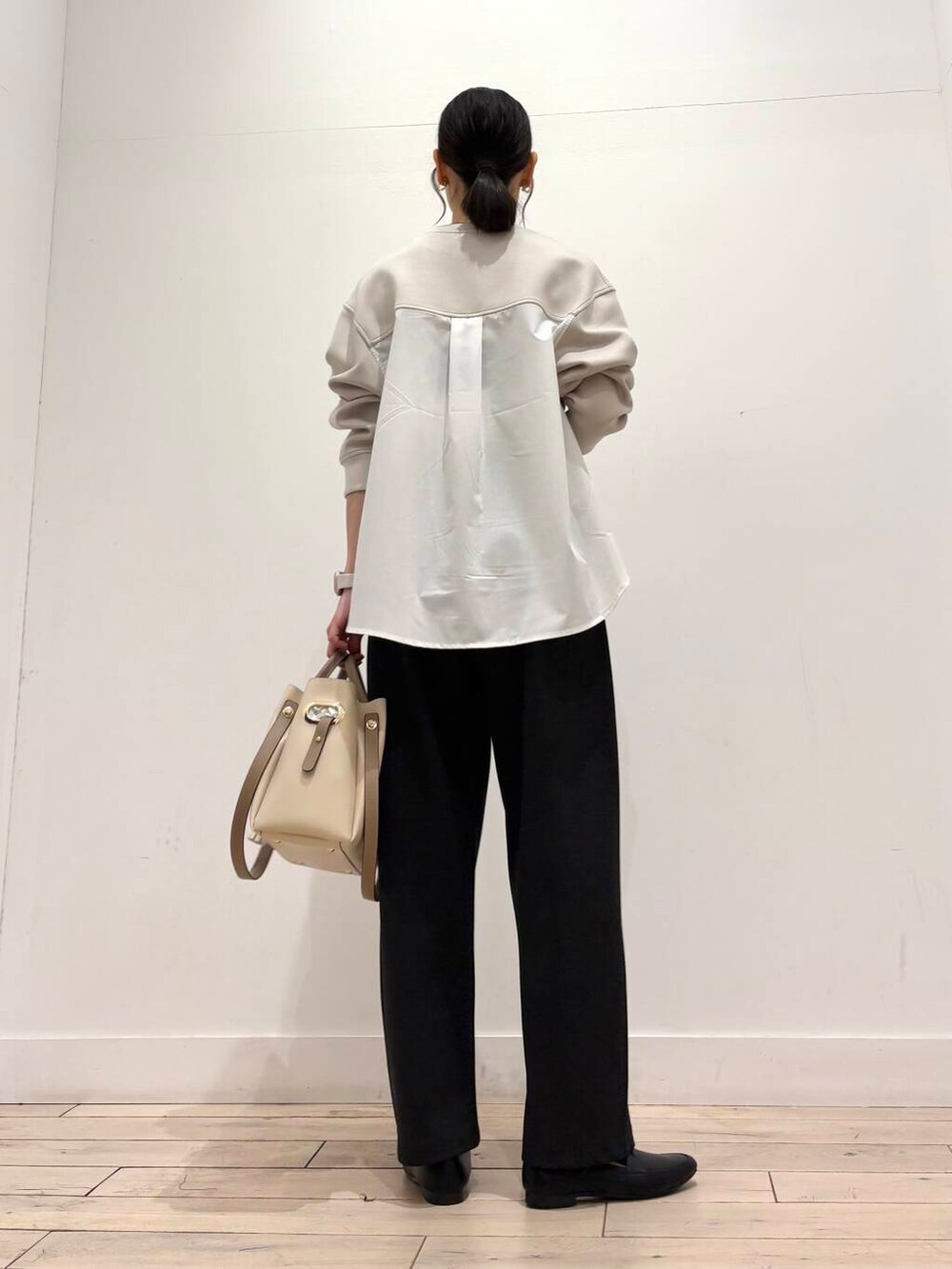 ホワイト系のトートバッグ、ブラック系のローファー、グレー系のその他パンツを着用したレディースの春コーディネートの5枚目の写真