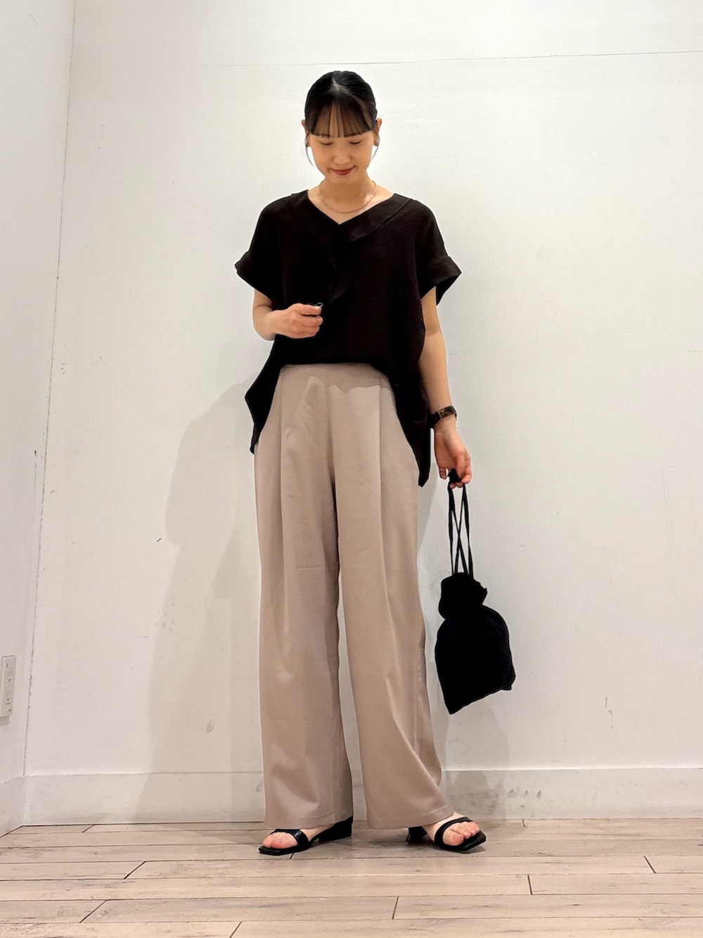 ベージュ系のその他パンツ、ブラック系のショルダーバッグ、ブラック系のサンダルを着用したレディースの夏コーディネートの2枚目の写真