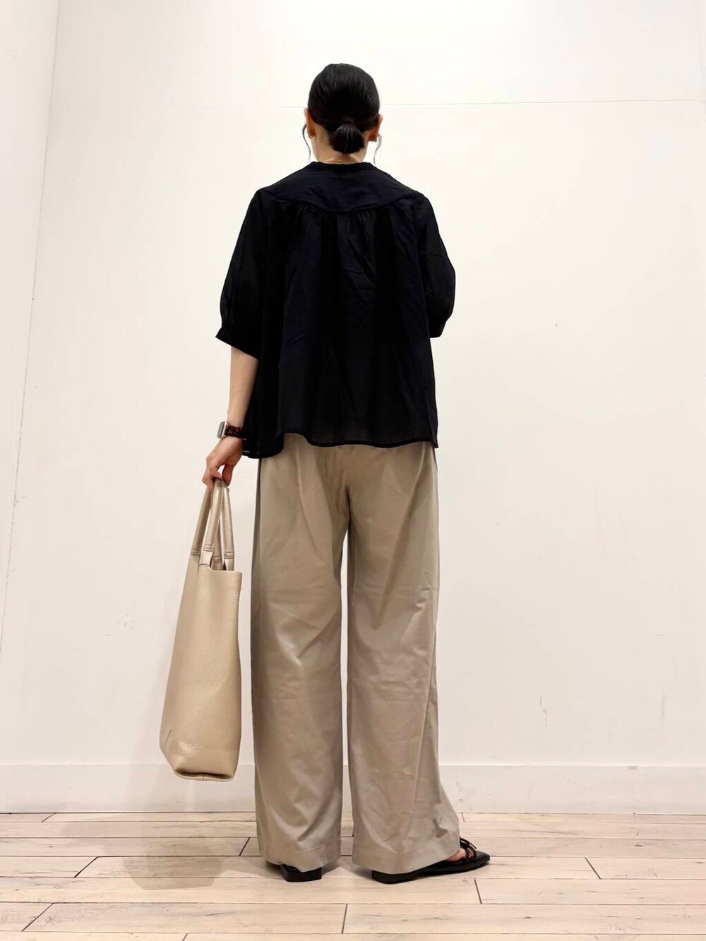 ベージュ系のその他パンツ、ゴールド系のトートバッグ、ブラック系のシャツ/ブラウスを着用したレディースの夏コーディネートの4枚目の写真