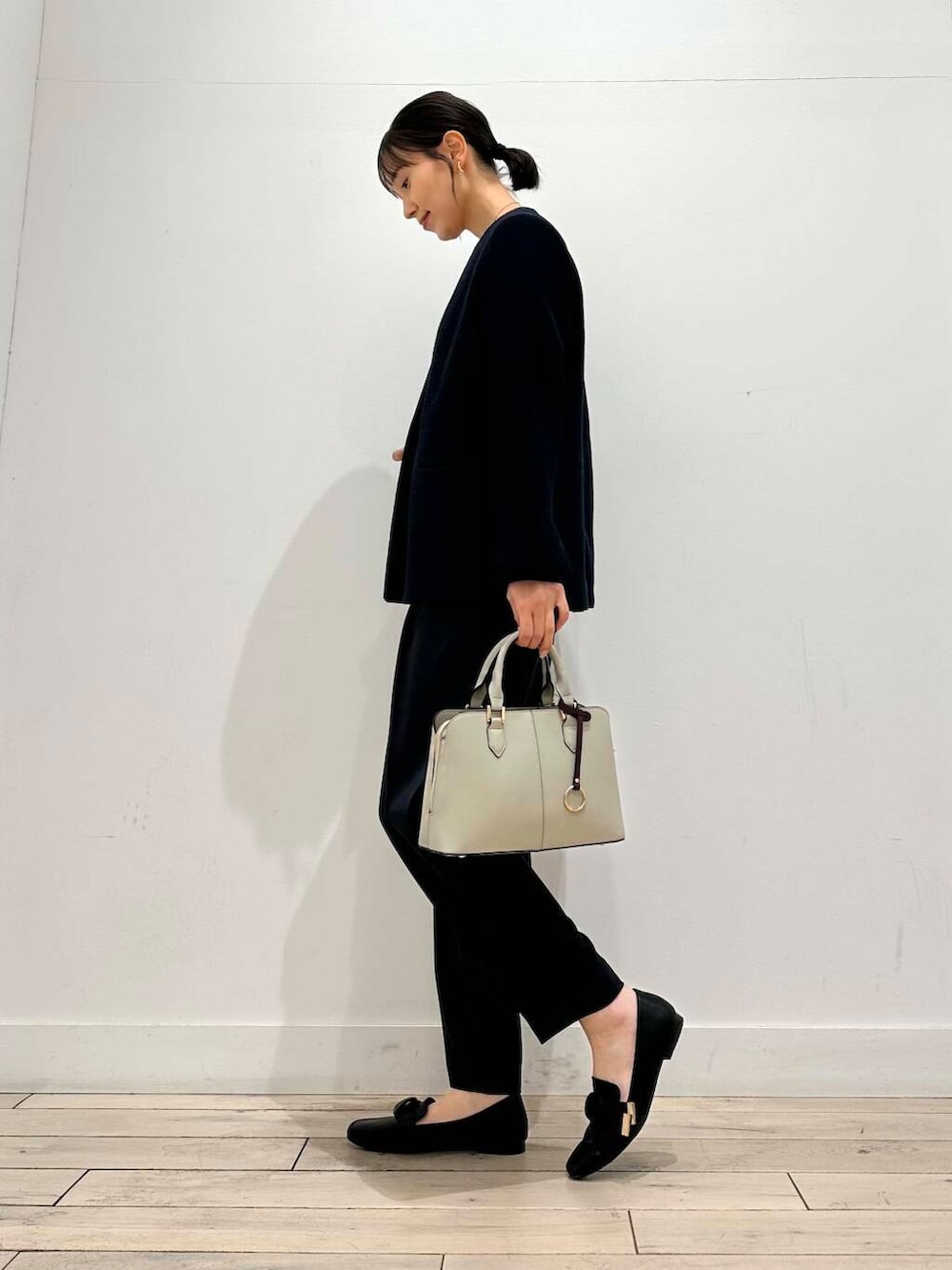ブラック系のドレスシューズ、グレー系のハンドバッグ、ブルー系のセットアップを着用したレディースの冬コーディネートの2枚目の写真