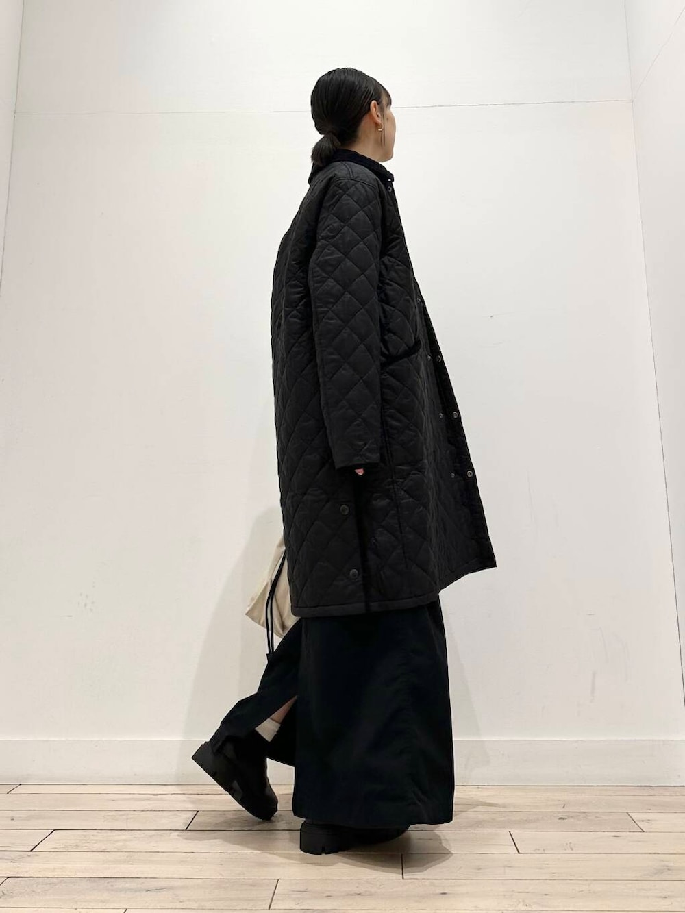 ホワイト系のショルダーバッグ、グレー系のニット/セーター、ブラック系のスカートを着用したレディースの冬コーディネートの7枚目の写真