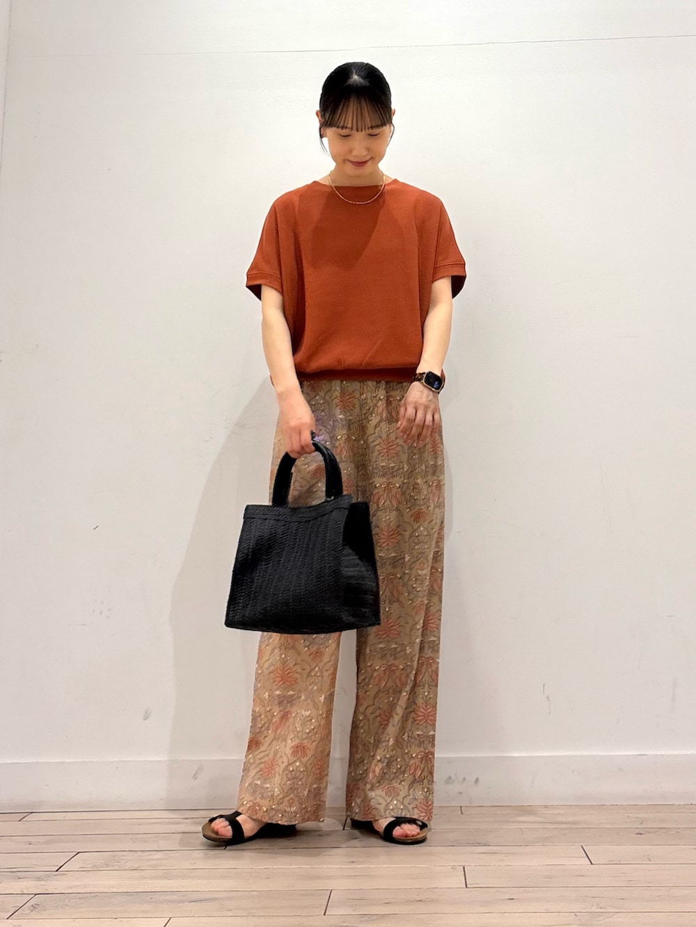 ブラック系のハンドバッグ、ベージュ系のその他パンツ、ブラック系のサンダルを着用したレディースの夏コーディネートの2枚目の写真