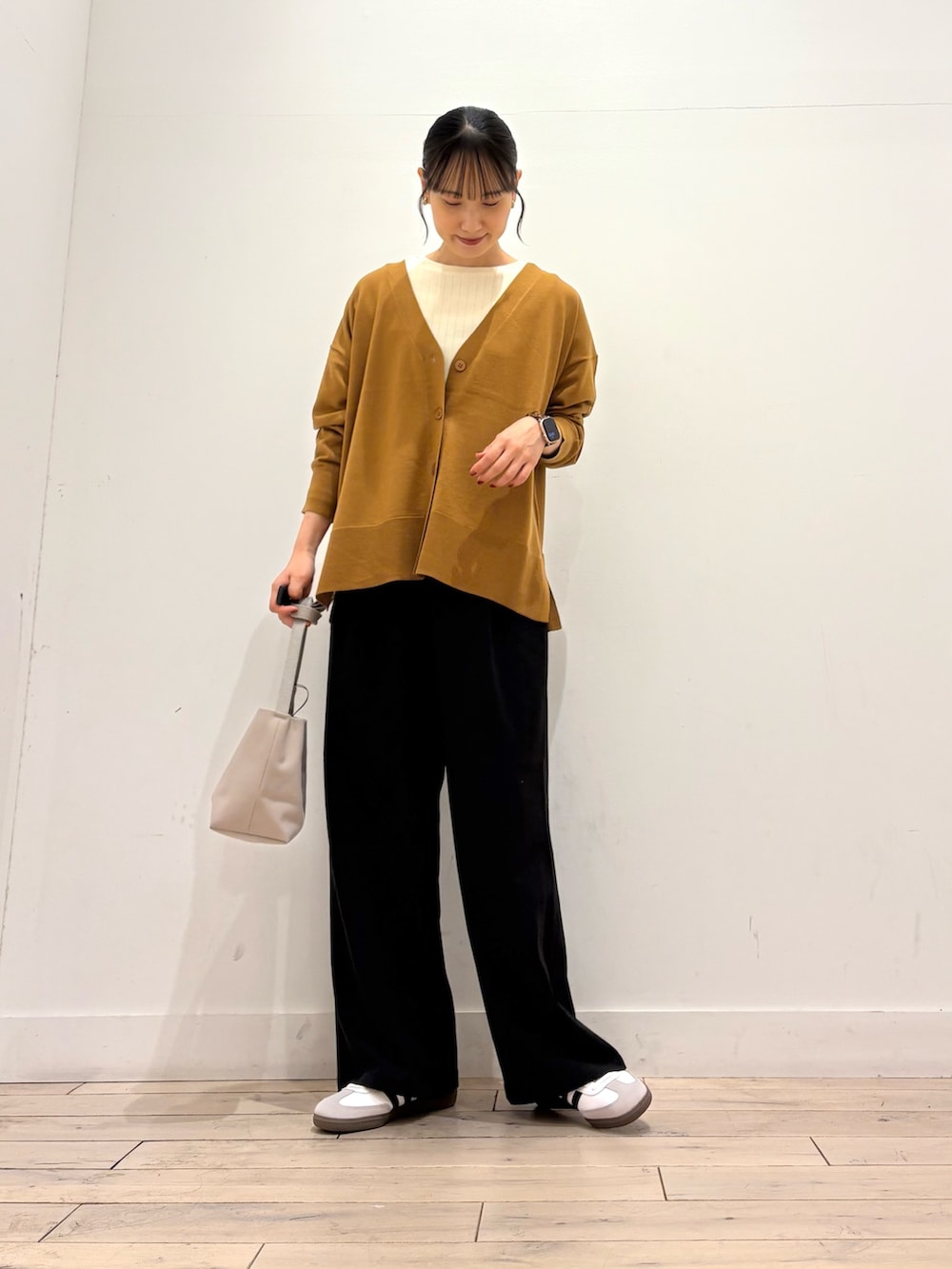 ゴールド系のカーディガン/ボレロ、ホワイト系のTシャツ/カットソー、ホワイト系のスニーカーを着用したレディースの秋コーディネートの3枚目の写真