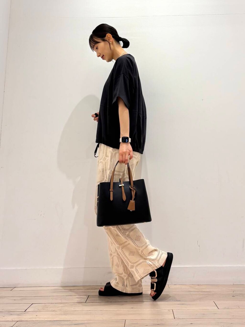 ブラック系のトートバッグ、グレー系のTシャツ/カットソー、ブラック系のサンダルを着用したレディースの夏コーディネートの3枚目の写真