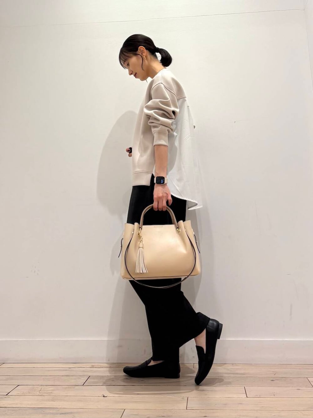 ホワイト系のトートバッグ、ブラック系のローファー、グレー系のその他パンツを着用したレディースの春コーディネートの4枚目の写真