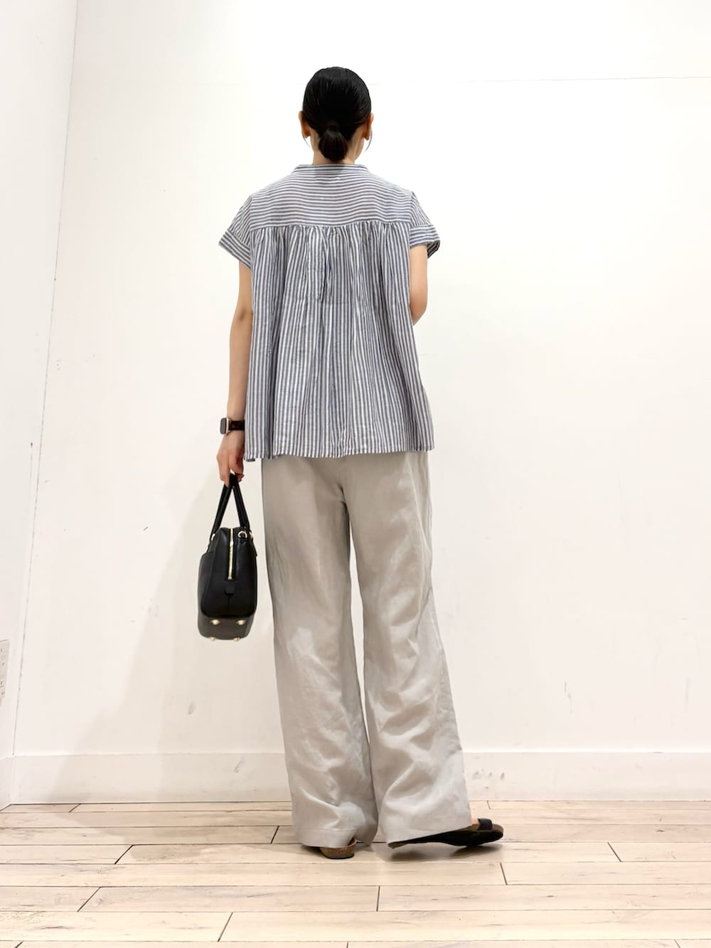 ブルー系のシャツ/ブラウス、ベージュ系のその他パンツ、ブラック系のボストンバッグを着用したレディースの夏コーディネートの3枚目の写真