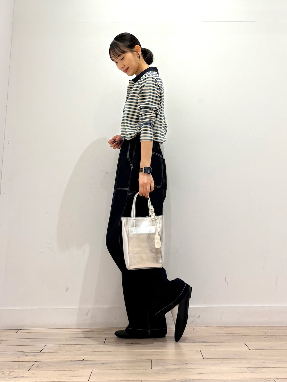 ホワイト系のポロシャツ、ブルー系のその他パンツ、シルバー系のトートバッグを着用したレディースの秋コーディネートの2枚目の写真