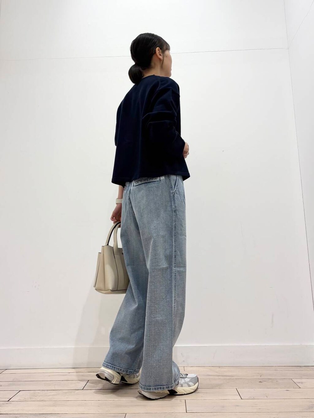 ホワイト系のスニーカー、ブルー系のデニムパンツ、グレー系のTシャツ/カットソーを着用したレディースの冬コーディネートの4枚目の写真