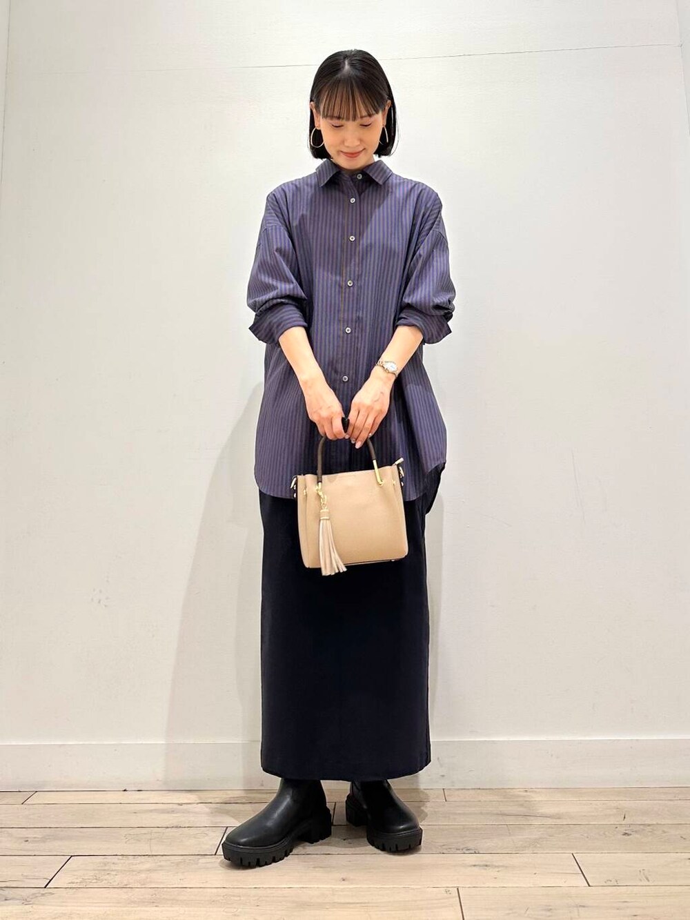 ベージュ系のトートバッグ、ブラック系のブーツ、ブルー系のシャツ/ブラウスを着用したレディースの秋コーディネートの2枚目の写真