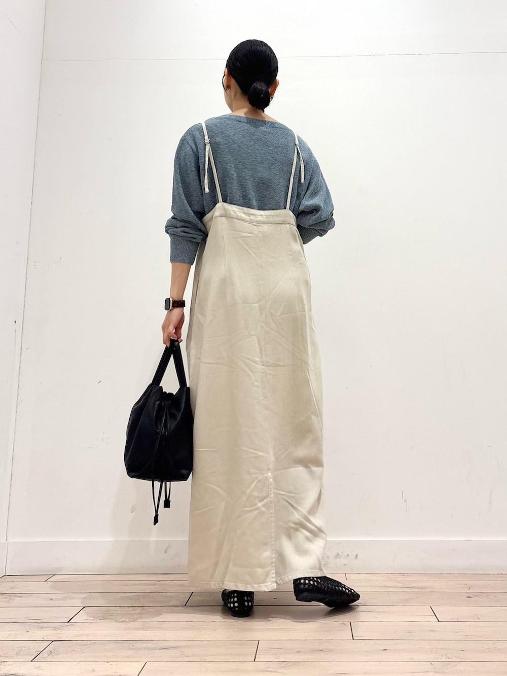 ブルー系のニット/セーター、ブラック系のショルダーバッグ、ブラック系のサンダルを着用したレディースの春コーディネートの4枚目の写真