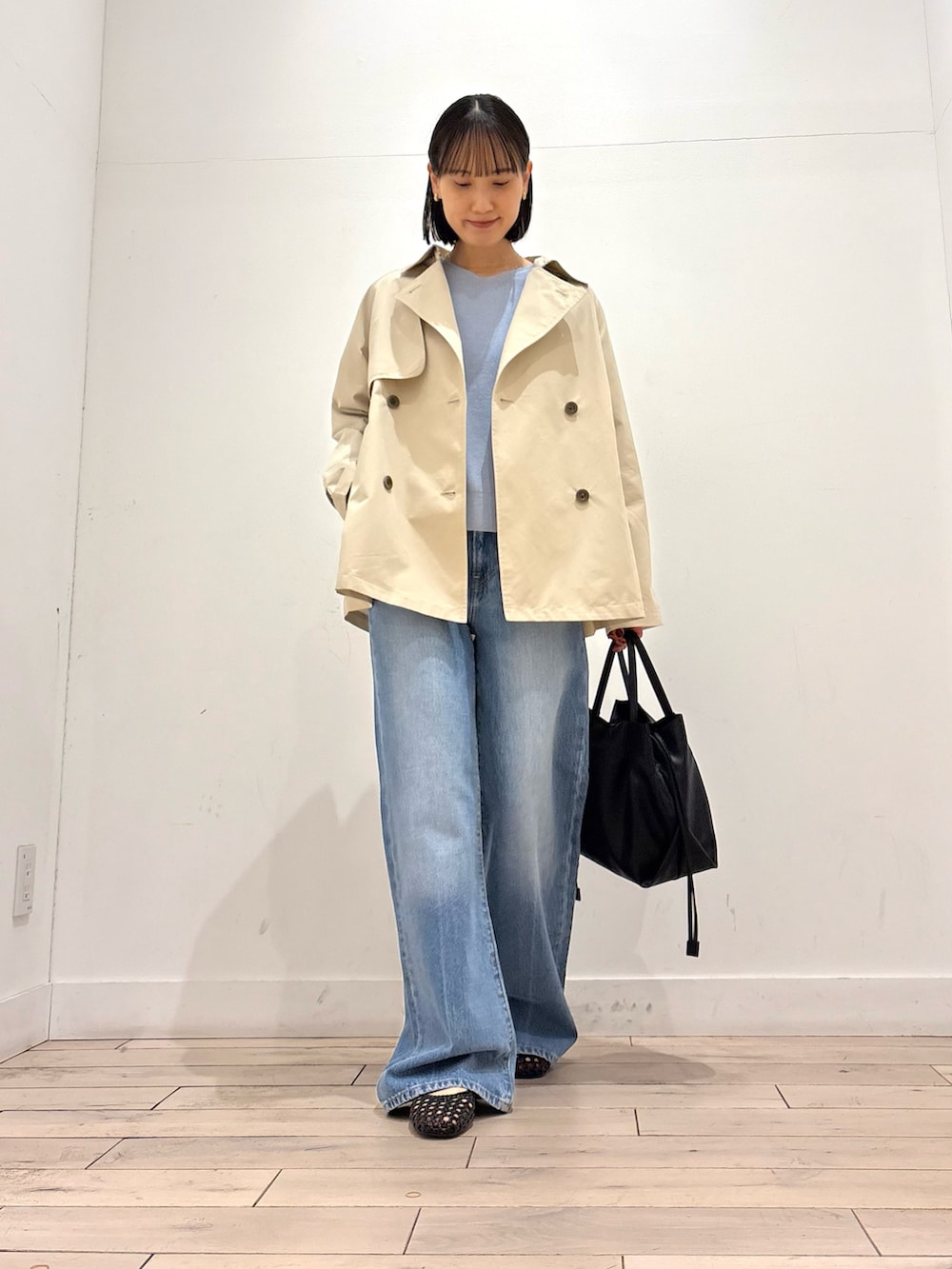 ベージュ系のトレンチコート、ブルー系のニット/セーター、ブラック系のサンダルを着用したレディースの春コーディネートの3枚目の写真