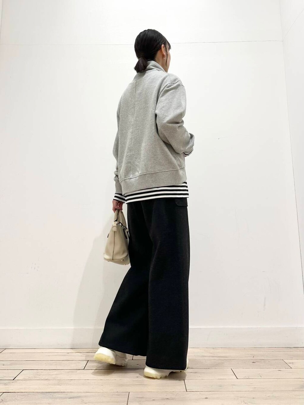 ホワイト系のスニーカー、ブラック系のダウンジャケット/コート、ホワイト系のボストンバッグを着用したレディースの冬コーディネートの3枚目の写真