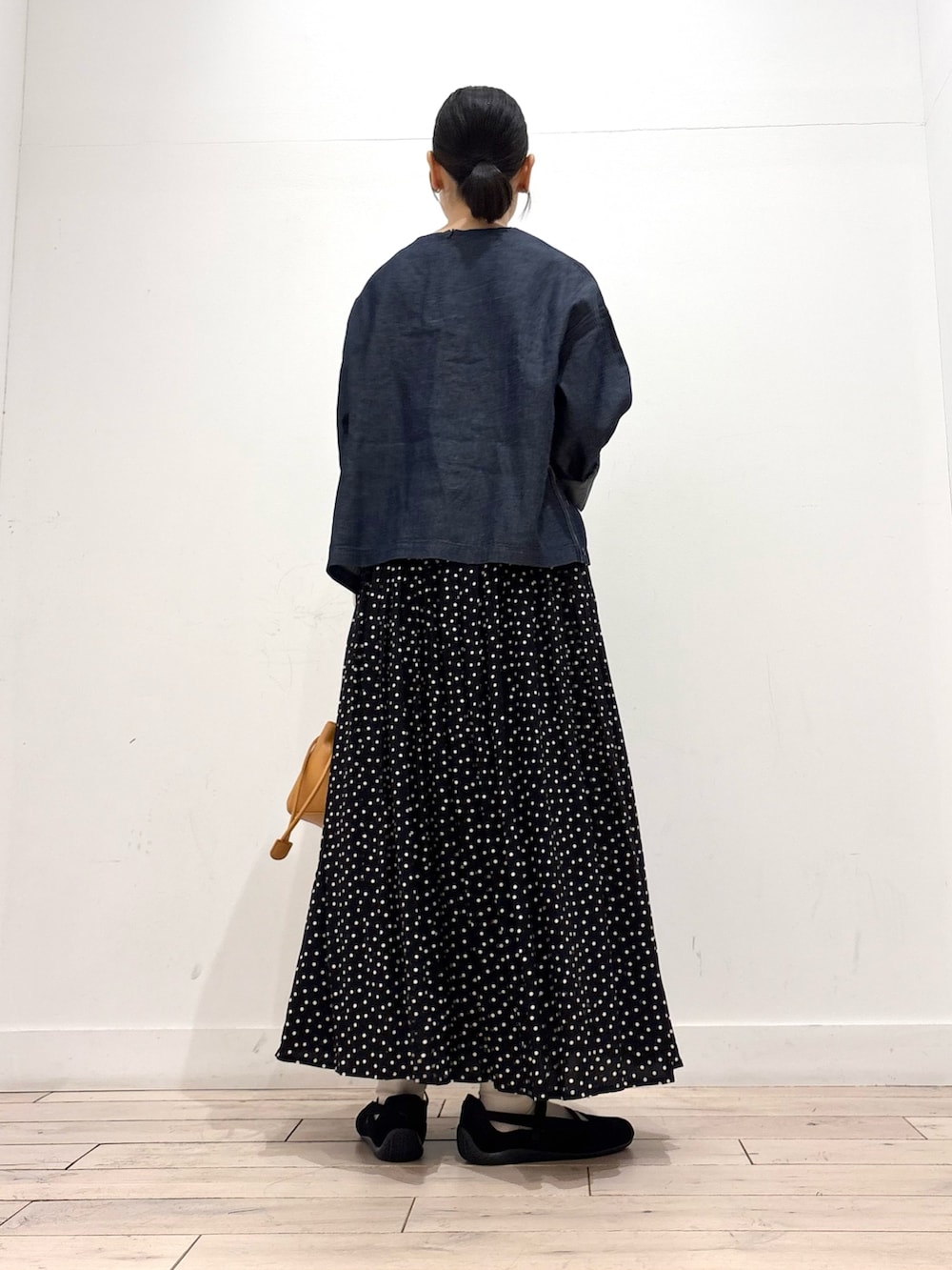 ブルー系のシャツ/ブラウス、ブラック系のスカート、オレンジ系のショルダーバッグを着用したレディースの春コーディネートの4枚目の写真
