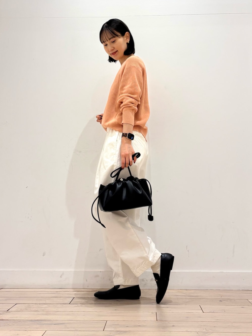 ピンク系のニット/セーター、ホワイト系のその他パンツ、ブラック系のショルダーバッグを着用したレディースの春コーディネートの3枚目の写真