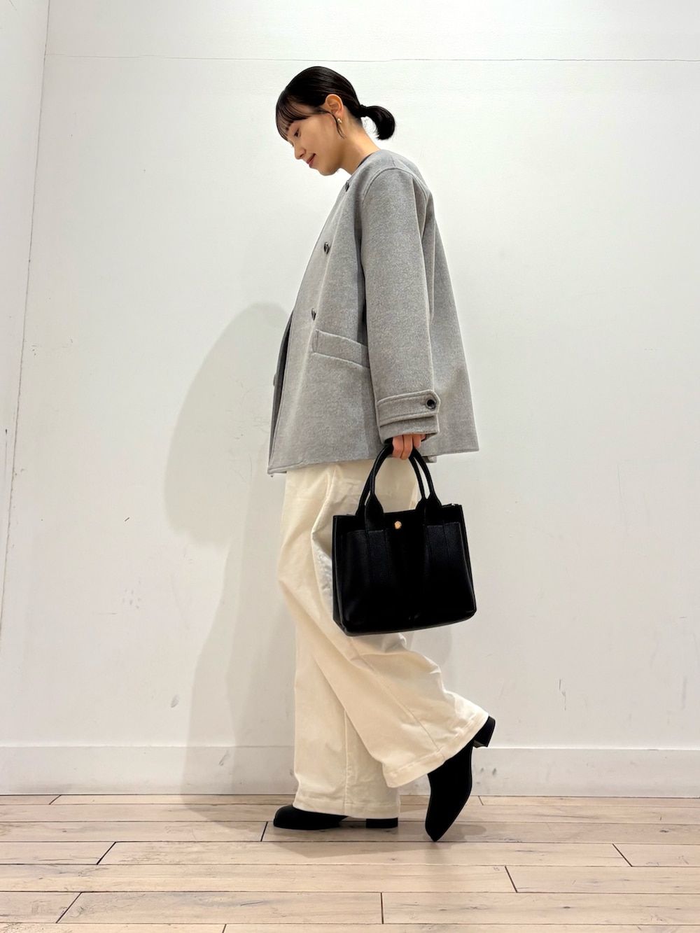 グレー系のピーコート、グレー系のニット/セーター、ブラック系のブーツを着用したレディースの冬コーディネートの5枚目の写真