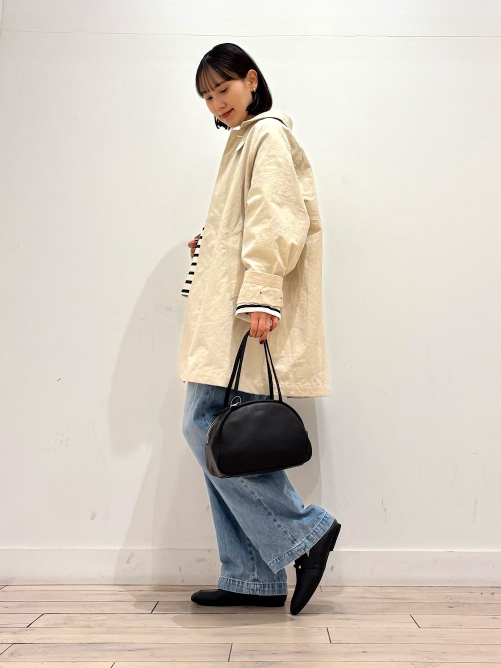 ブラック系のTシャツ/カットソー、ホワイト系のその他アウター、ブラック系のボストンバッグを着用したレディースの冬コーディネートの3枚目の写真