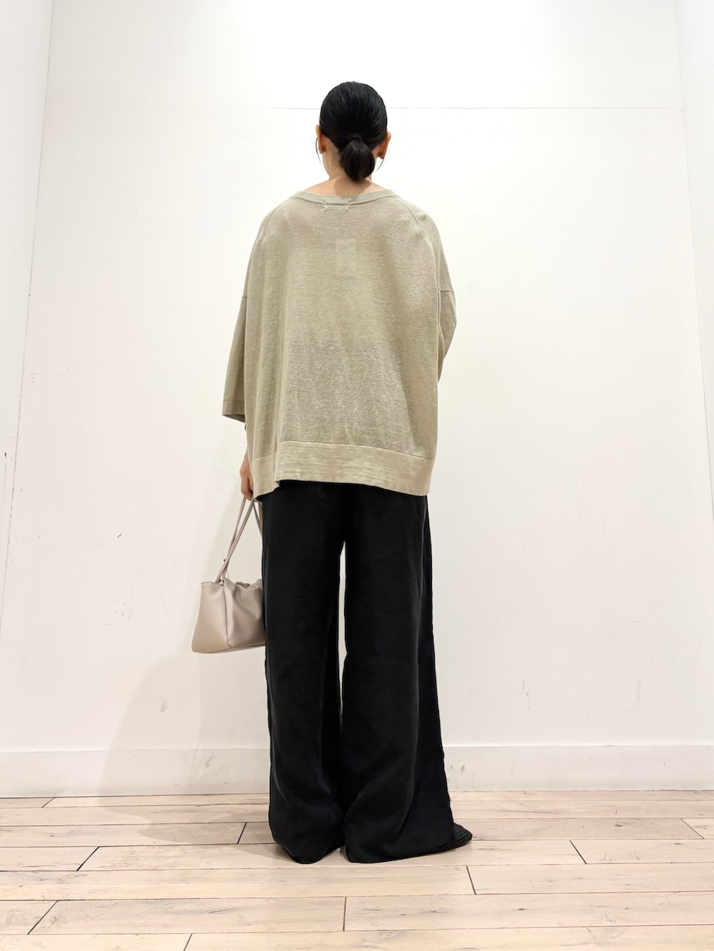 ベージュ系のニット/セーター、ブラック系のその他パンツ、ホワイト系のショルダーバッグを着用したレディースの夏コーディネートの3枚目の写真
