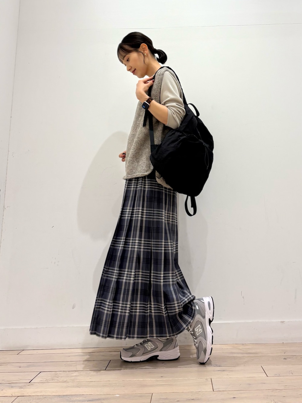 ベージュ系のTシャツ/カットソー、グレー系のニット/セーター、グレー系のスカートを着用したレディースの秋コーディネートの2枚目の写真