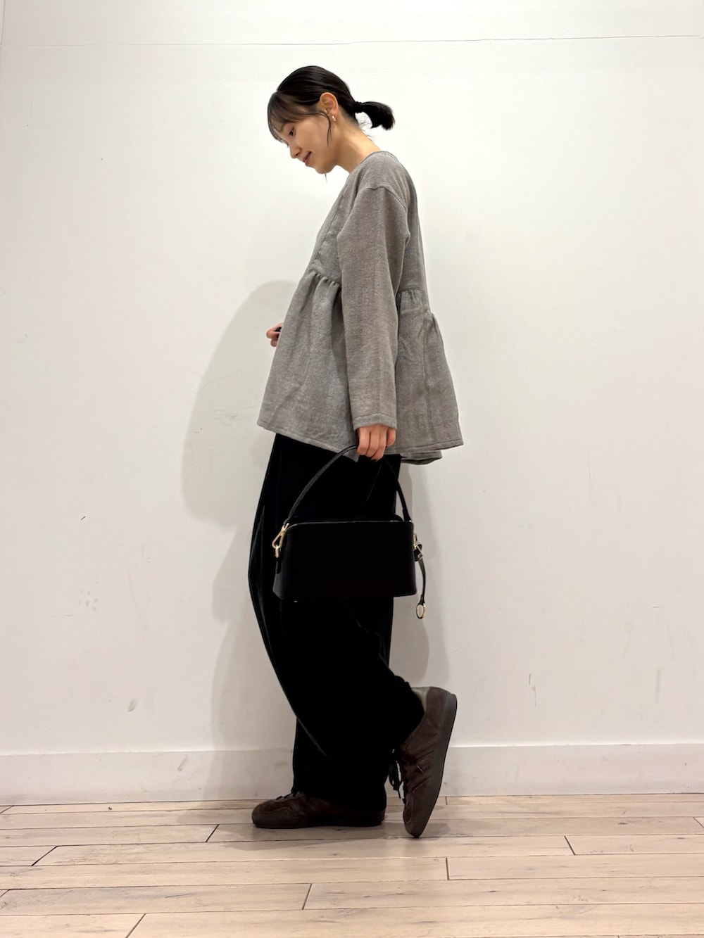 グレー系のシャツ/ブラウス、ブラウン系のスニーカー、ブラック系のショルダーバッグを着用したレディースの秋コーディネートの2枚目の写真