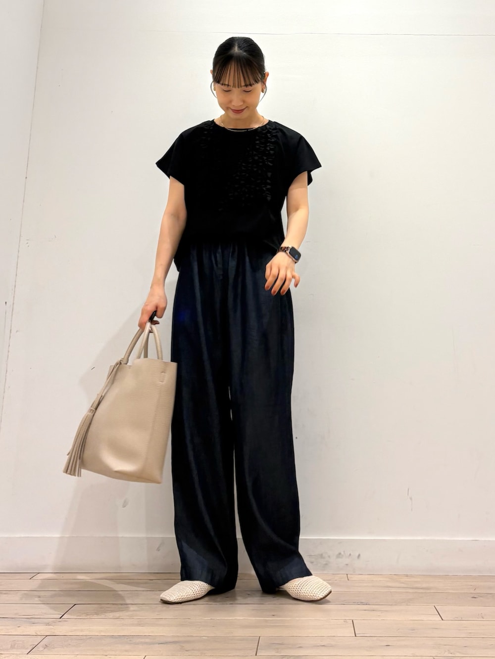 ブラック系のTシャツ/カットソー、ブルー系のデニムパンツ、ホワイト系のトートバッグを着用したレディースの夏コーディネートの2枚目の写真