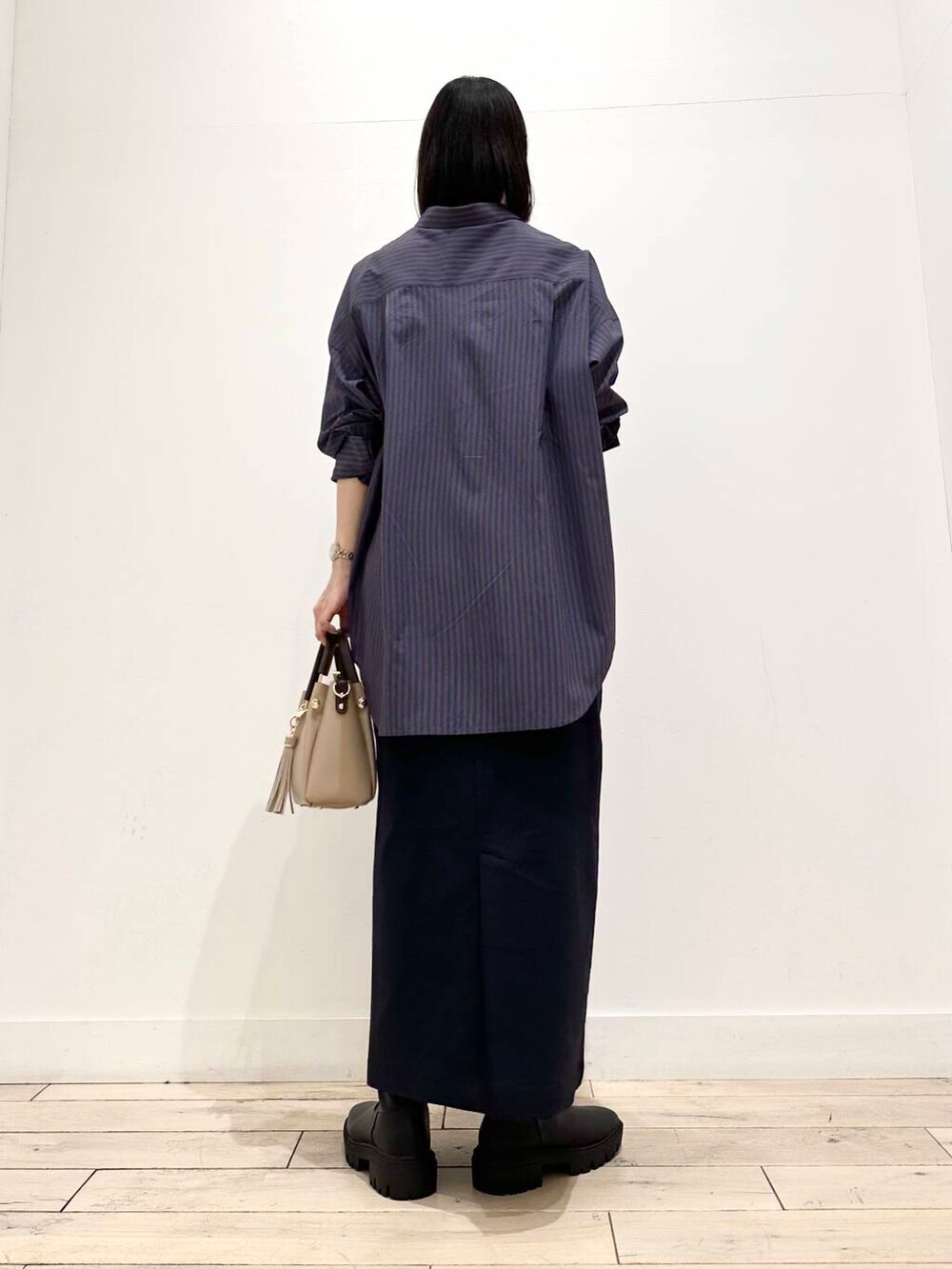 ベージュ系のトートバッグ、ブラック系のブーツ、ブルー系のシャツ/ブラウスを着用したレディースの秋コーディネートの4枚目の写真