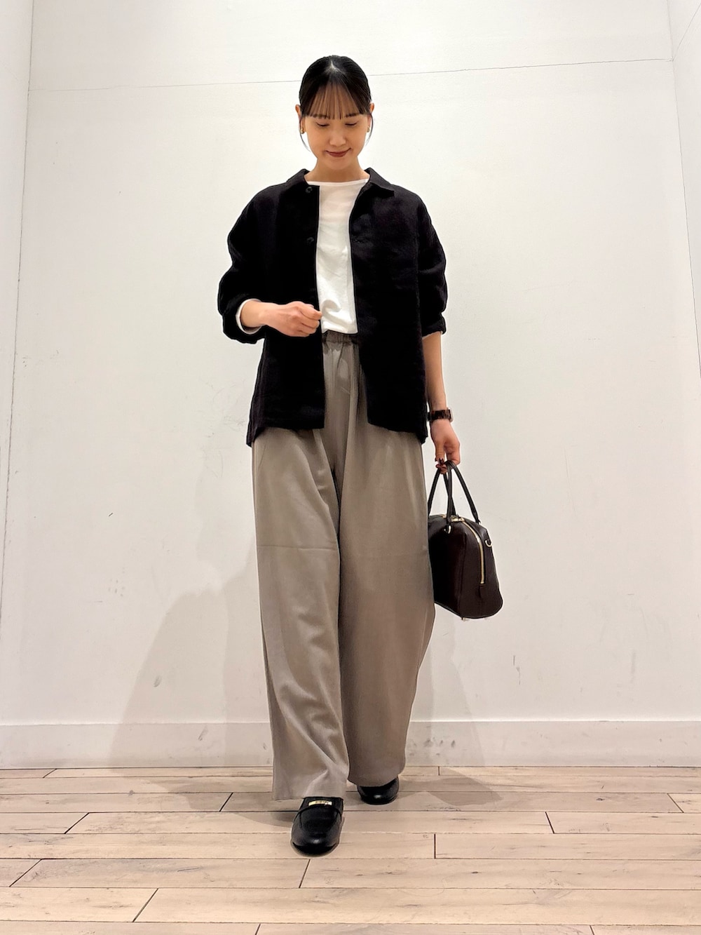 グレー系のカバーオール、グレー系のその他パンツ、ブラウン系のボストンバッグを着用したレディースの春コーディネートの3枚目の写真