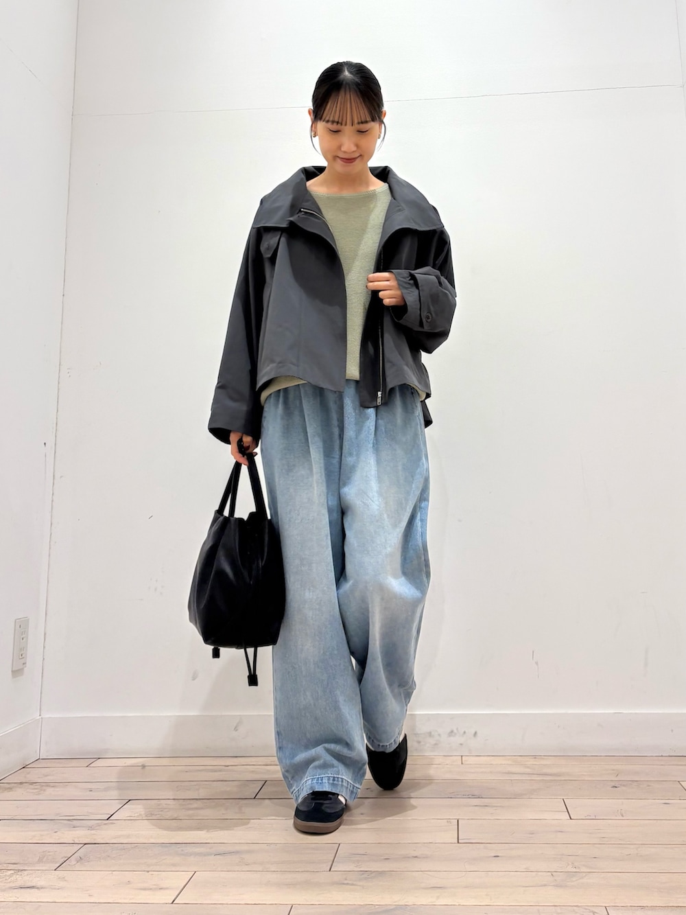 グリーン系のニット/セーター、グレー系のその他アウター、ブラック系のショルダーバッグを着用したレディースの春コーディネートの3枚目の写真