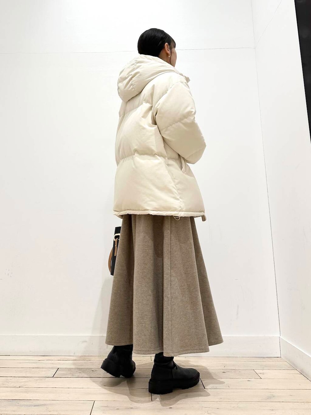 ブラック系のトートバッグ、ブラック系のブーツ、その他のニット/セーターを着用したレディースの冬コーディネートの6枚目の写真