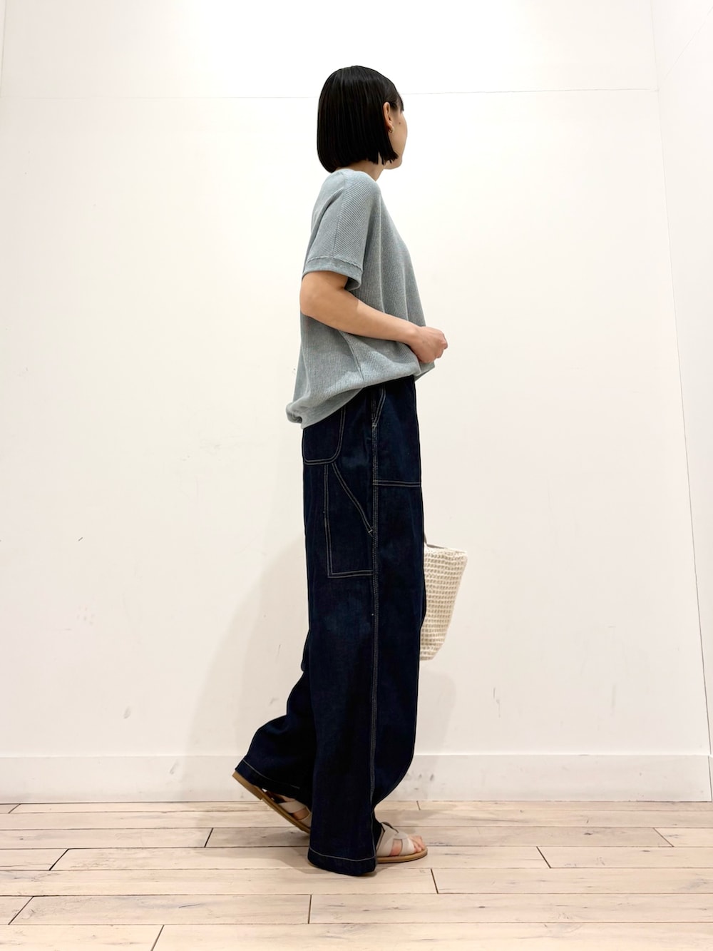 ブルー系のTシャツ/カットソー、ブルー系のデニムパンツ、ホワイト系のトートバッグを着用したレディースの春コーディネートの5枚目の写真