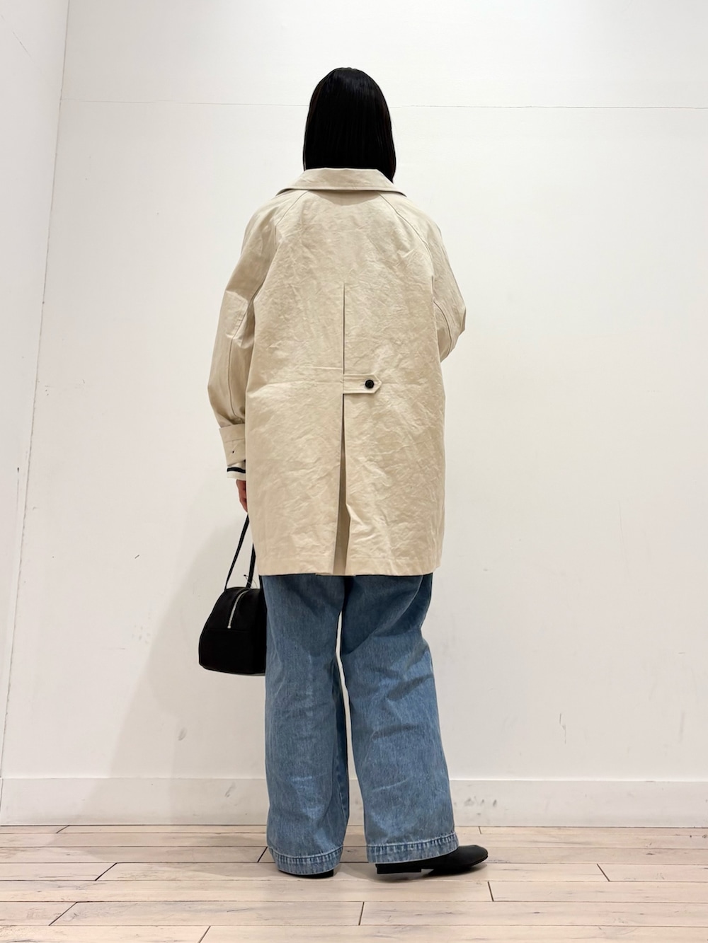 ブラック系のTシャツ/カットソー、ホワイト系のその他アウター、ブラック系のボストンバッグを着用したレディースの冬コーディネートの4枚目の写真