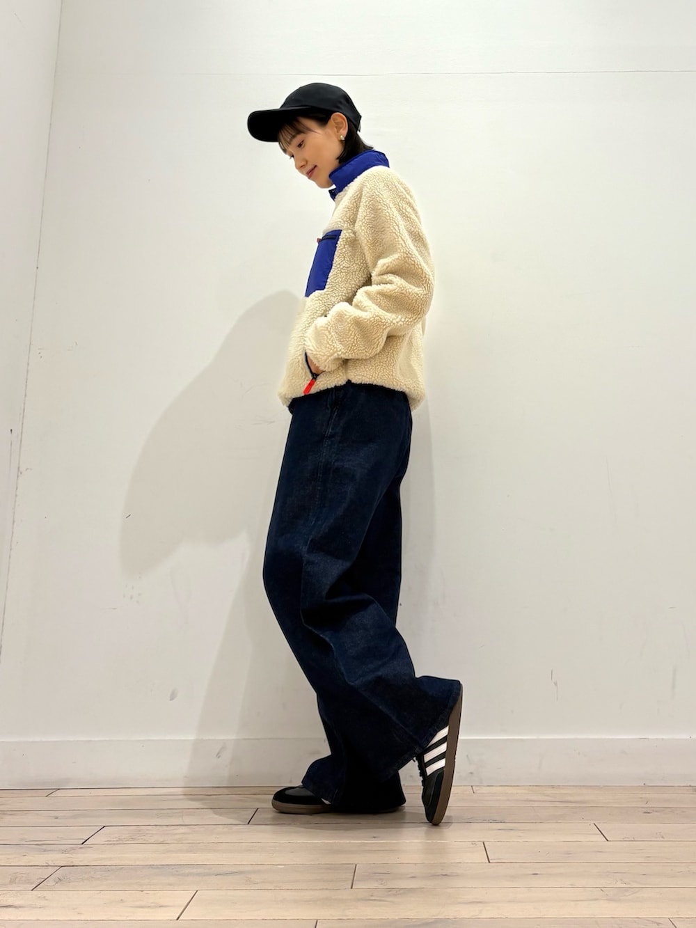 ブルー系のテーラードジャケット、ブルー系のデニムパンツ、ブラック系のスニーカーを着用したレディースの秋コーディネートの2枚目の写真