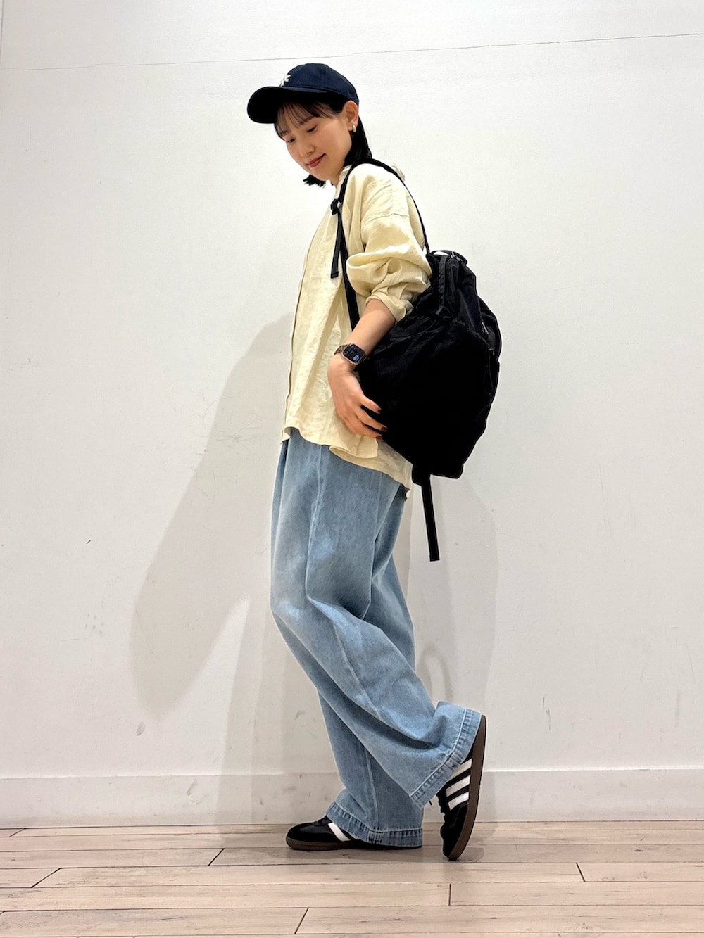 ブルー系のデニムパンツ、ブラック系のスニーカー、ブラック系のバックパック/リュックを着用したレディースの春コーディネートの3枚目の写真