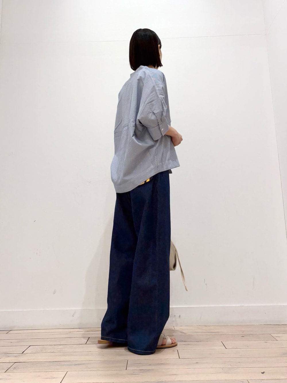 ホワイト系のタンクトップ、ブルー系のシャツ/ブラウス、ブルー系のデニムパンツを着用したレディースの春コーディネートの4枚目の写真