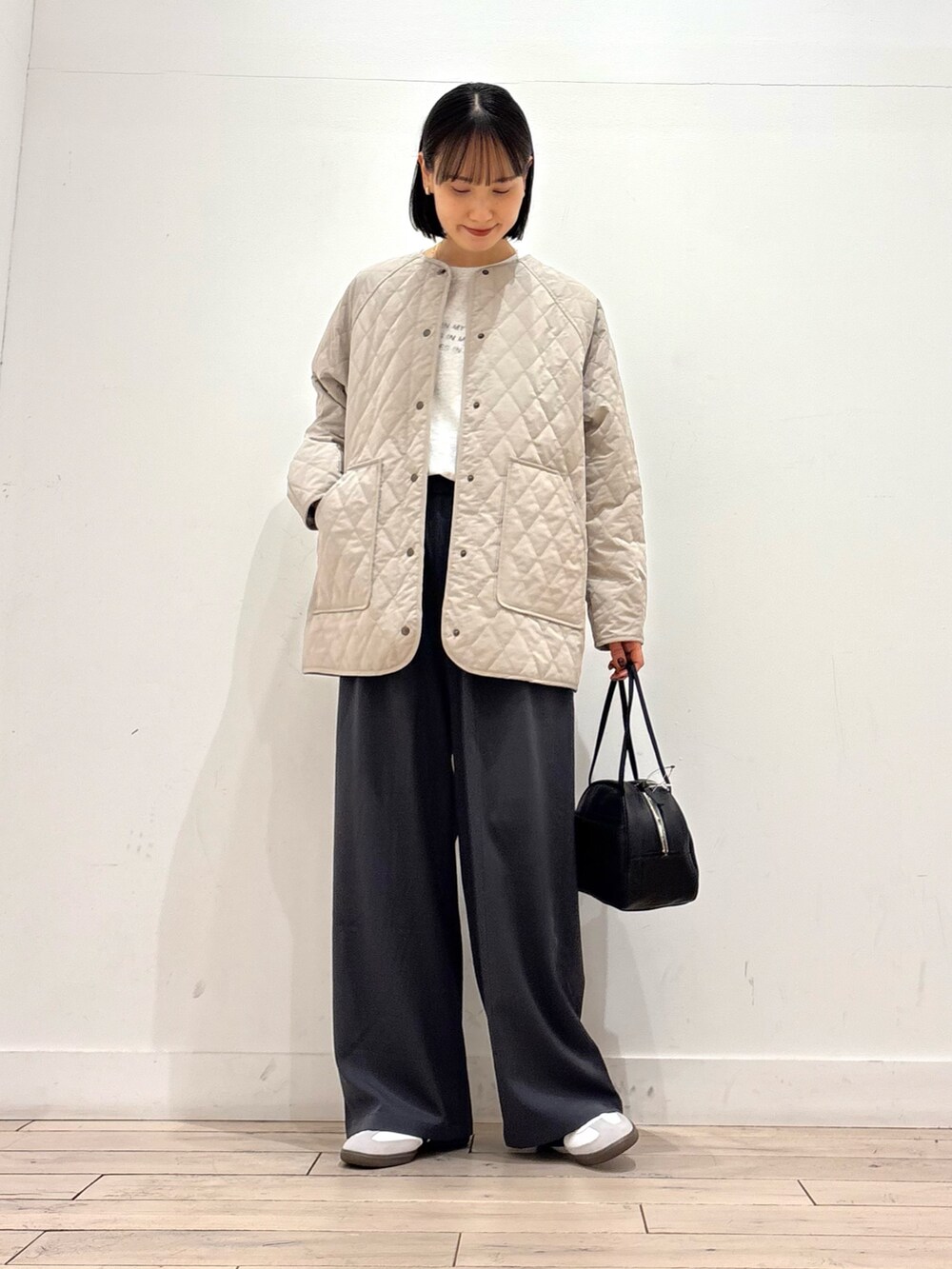グレー系のその他パンツ、ホワイト系のスニーカー、ブラック系のボストンバッグを着用したレディースの冬コーディネートの2枚目の写真