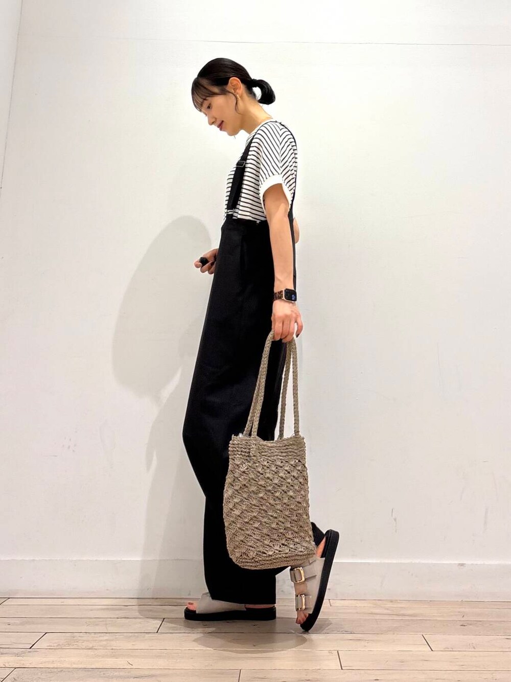 グレー系のトートバッグ、グレー系のサンダル、ブラック系のその他パンツを着用したレディースの夏コーディネートの2枚目の写真