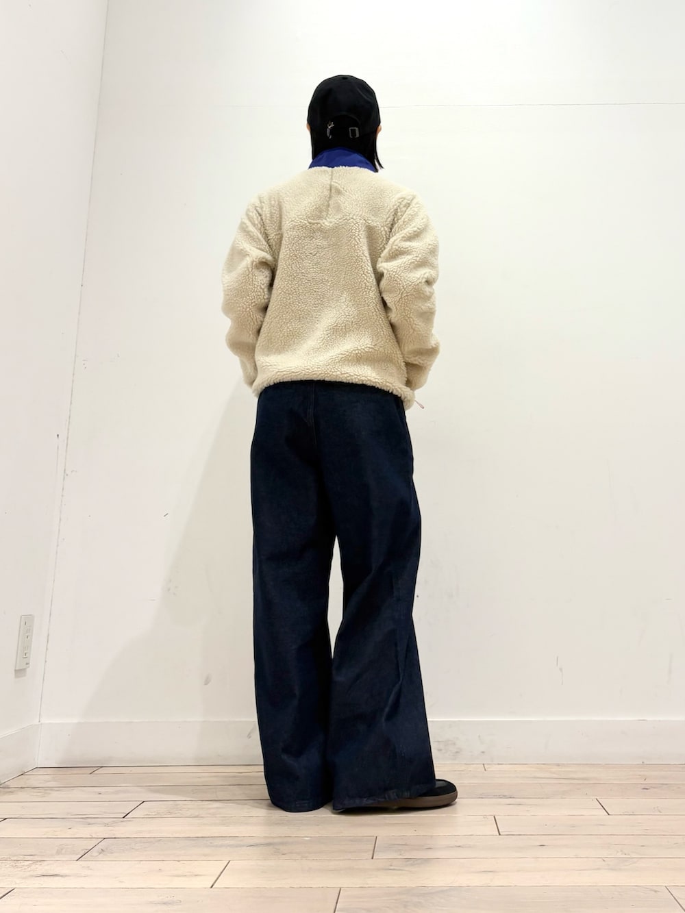 ブルー系のテーラードジャケット、ブルー系のデニムパンツ、ブラック系のスニーカーを着用したレディースの秋コーディネートの4枚目の写真