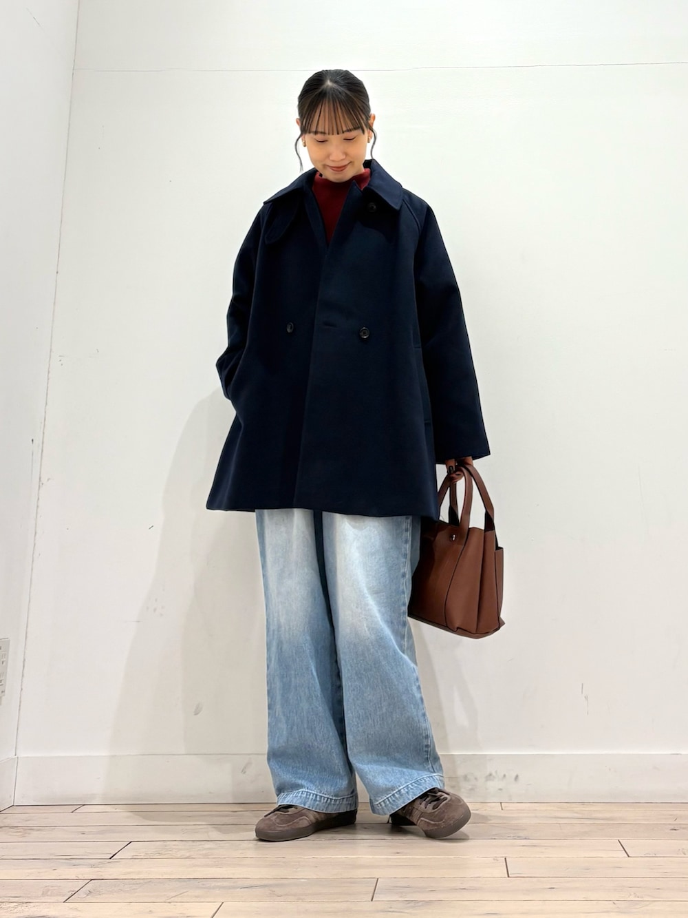 レッド系のニット/セーター、ブルー系のその他アウター、ブルー系のデニムパンツを着用したレディースの冬コーディネートの2枚目の写真