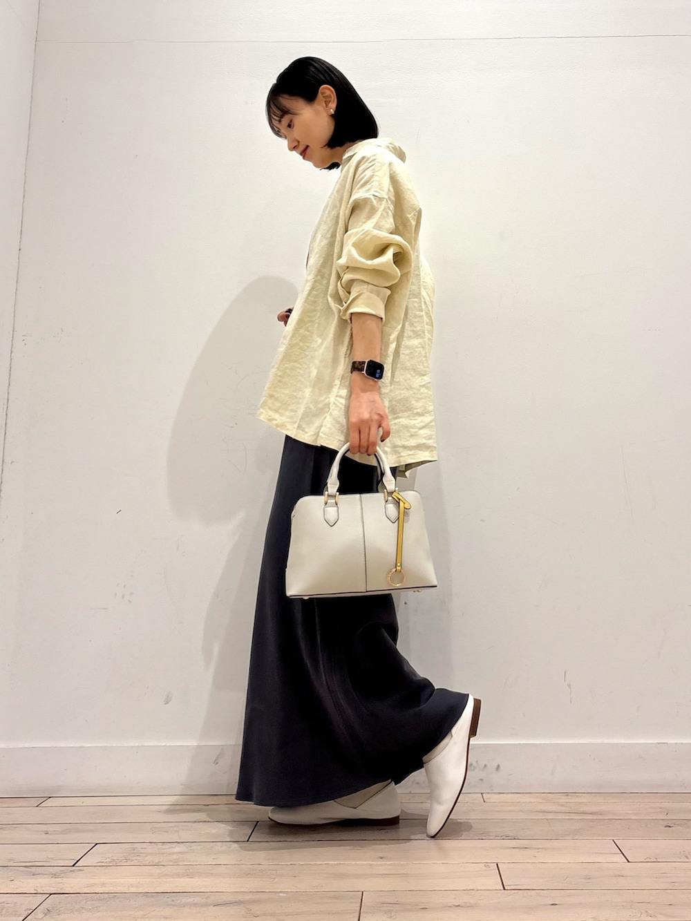 イエロー系のシャツ/ブラウス、ホワイト系のその他シューズ、グレー系のスカートを着用したレディースの春コーディネートの3枚目の写真