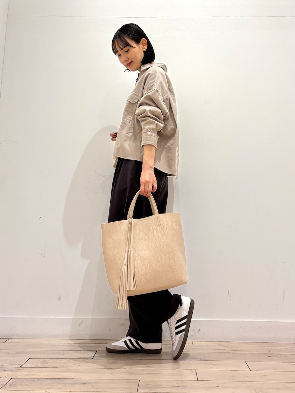 ベージュ系のシャツ/ブラウス、ブラウン系のその他パンツ、ホワイト系のスニーカーを着用したレディースの冬コーディネートの2枚目の写真