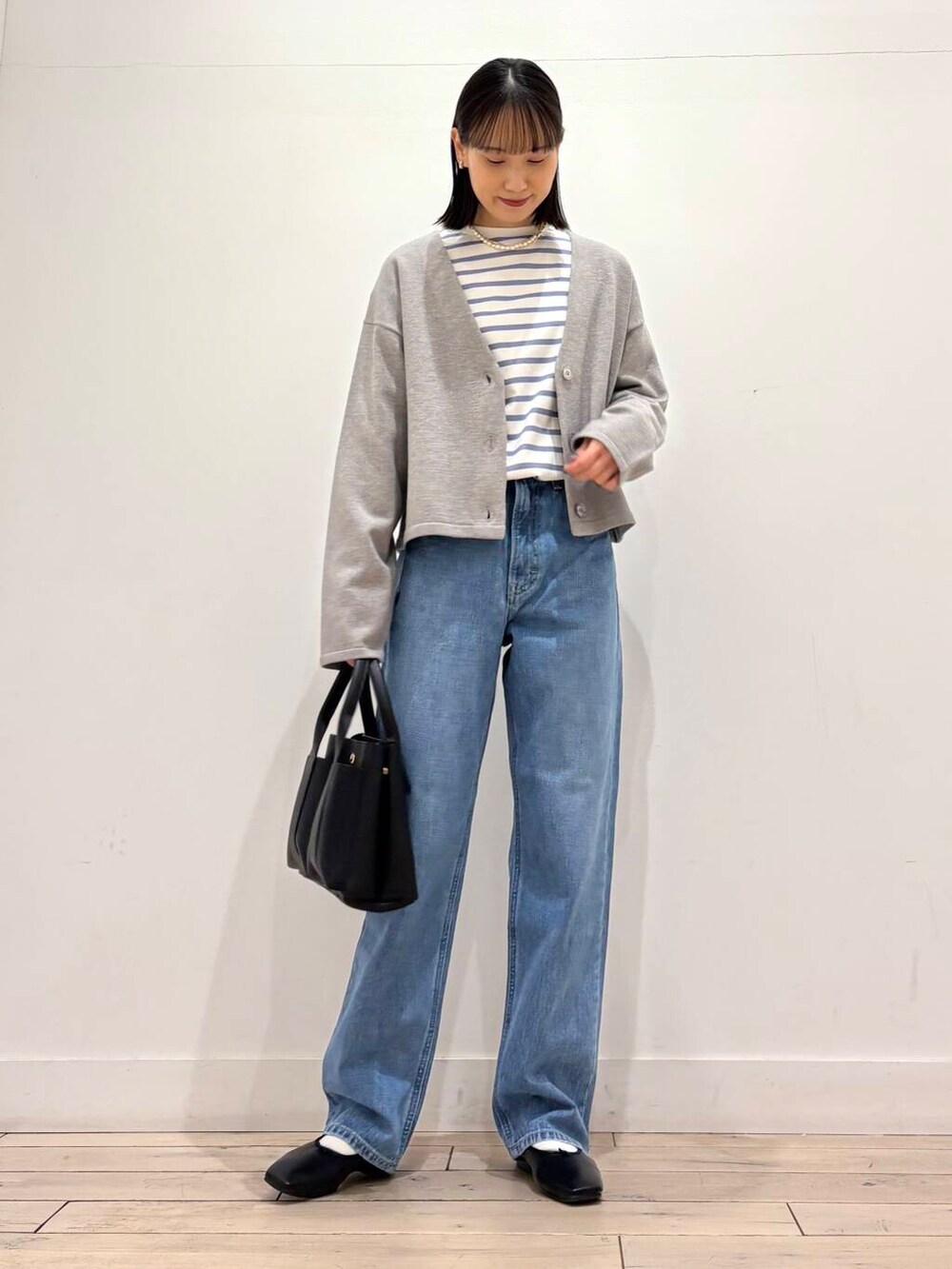 ブラック系のトートバッグ、グレー系のカーディガン/ボレロ、ホワイト系のノーカラージャケットを着用したレディースの冬コーディネートの4枚目の写真