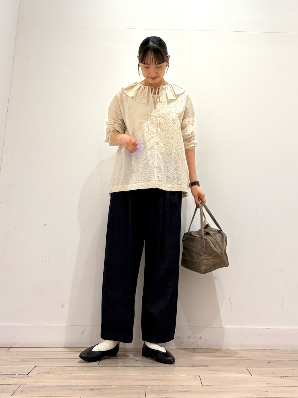 ホワイト系のシャツ/ブラウス、ブルー系のデニムパンツ、グリーン系のハンドバッグを着用したレディースの秋コーディネートの2枚目の写真