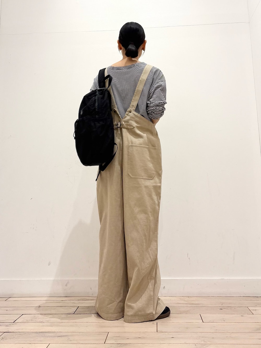 ブラック系のTシャツ/カットソー、ブラック系のバックパック/リュック、ブラック系のスニーカーを着用したレディースの春コーディネートの5枚目の写真