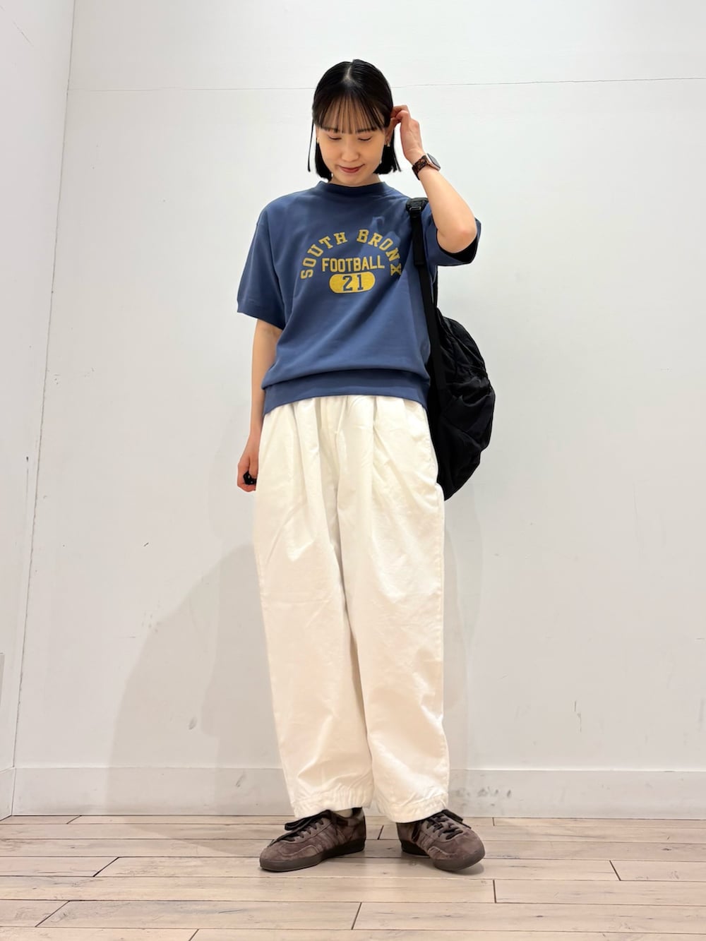 ブルー系のスウェット、ホワイト系のその他パンツ、ブラック系のバックパック/リュックを着用したレディースの春コーディネートの2枚目の写真